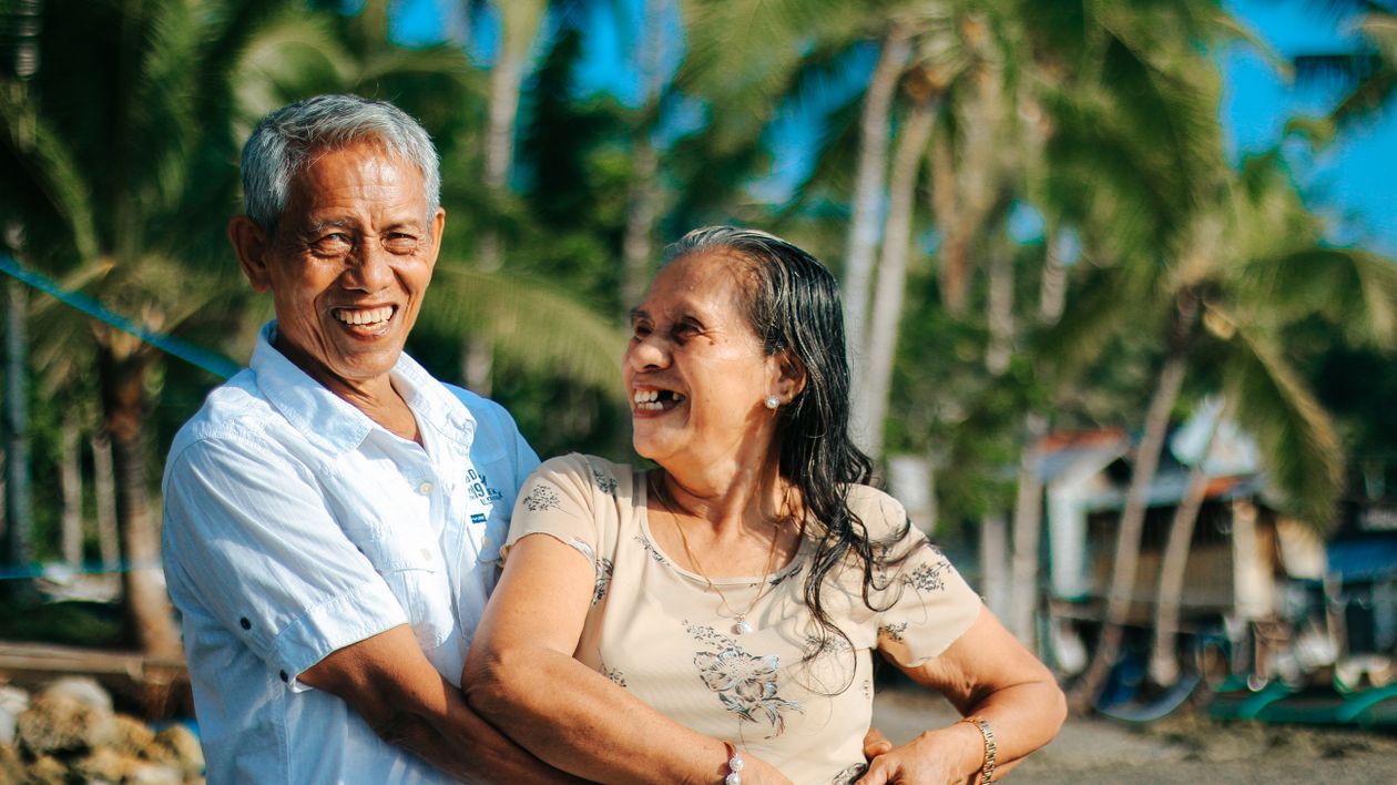 An older couple smiling together outdoors